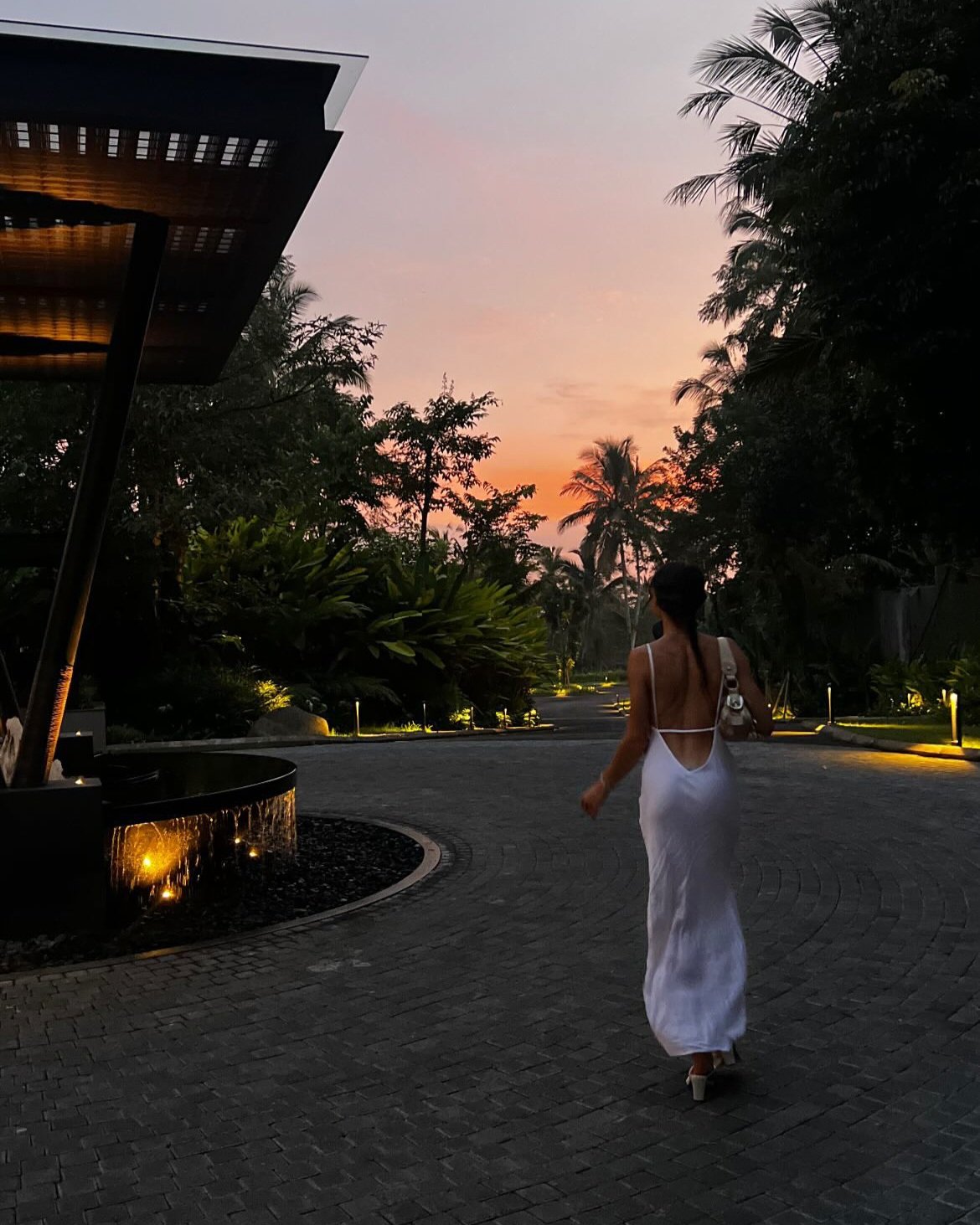 Woman walking into Ayatara Villa during golden hour at sunset in Ubud Bali